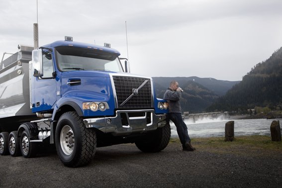 Blue-VHD-with-driver-and-mountains Blue Volvo VHD Truck with Driver and Mountains